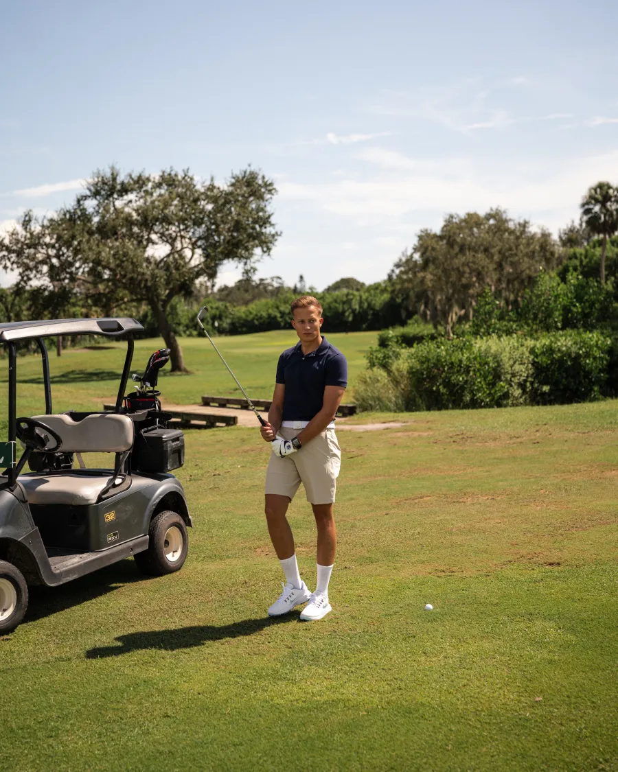 Torin on a golf course holding a club
